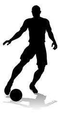 A soccer or football player in silhouette