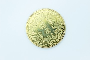 Gold bitcoin coin located on a white background