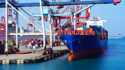 A huge container ship in the cargo terminal of an Asian port in Taiwan. Port container cranes load...