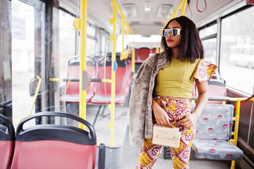 Young stylish african american woman in modern sunglasses riding on a bus.