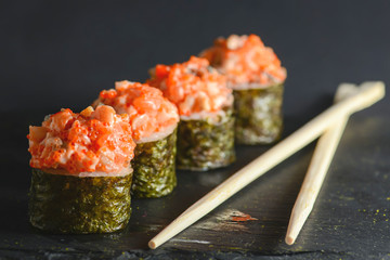 Set of four pieces of spicy Maki sushi rolls with sauced slices of smoked Eel, cheese and caviar of...