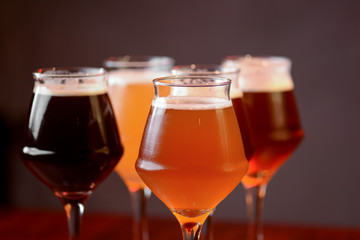 Three glasses with different beer on wooden table in a bar. Food photography concept, with copy space