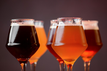 Three glasses with different beer on wooden table in a bar. Food photography concept, with copy space