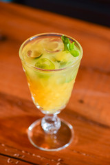 Cider, mulled wine made from white wine in a glass on a wooden table with blurred background.