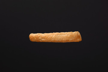 Fresh burger bun with sesame seeds on top isolated on black background. Copy space. Ingridients for making a hamburger.