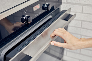 Close up of hand opening the oven door