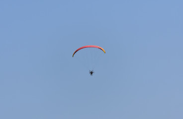 a paraglider against blue sky