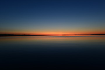 Glowing twilight red colors on the horizon on a blue sky background at sunset