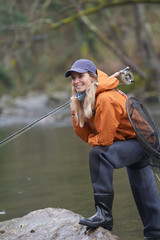 Obraz premium woman fly fishing in river