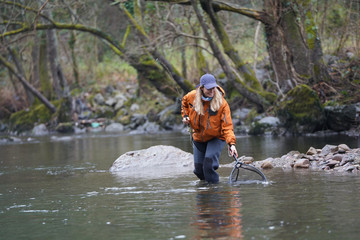 woman fly fishing catching rainbow trout