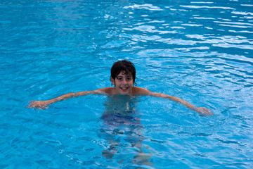 Cute boy playing in swimming pool