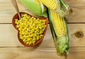 The corn cobs and grains corn on the table close-up