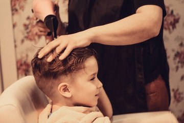 Obraz na płótnie Canvas Small boy getting his hair dried after a haircut.