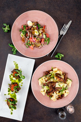 A few dishes shot from above pasta with meat, vegetable salad