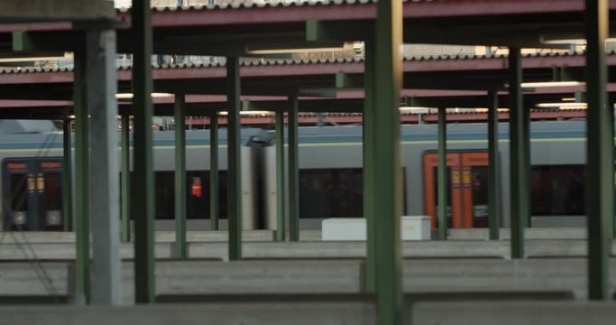 Slow motion wide 4K cinema camera shot with parallax motion of gray and green locomotive train leaving terminal platform at Oslo central commerce train station, in Bj&oslash;rvika Oslo Norway.