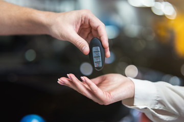 man sales manager giving keys from brand new car to his woman client , successful purchase deal, positive cooperation