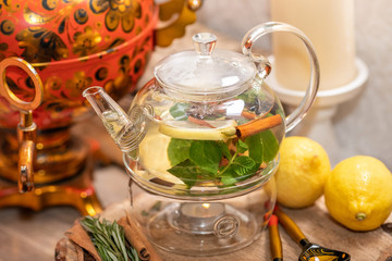 Hot green tea candle basking with lemon, mint, ginger, cinnamon and honey on wooden background. Food and drink, still life health care concept.