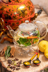 Hot green tea candle basking with lemon, mint, ginger, cinnamon and honey on wooden background. Food and drink, still life health care concept.