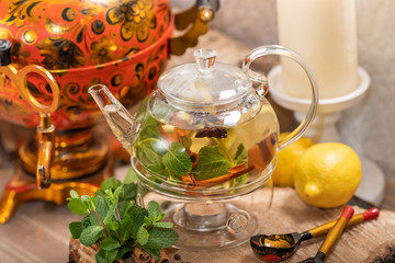 Hot green tea candle basking with lemon, mint, ginger, cinnamon and honey on wooden background. Food and drink, still life health care concept.