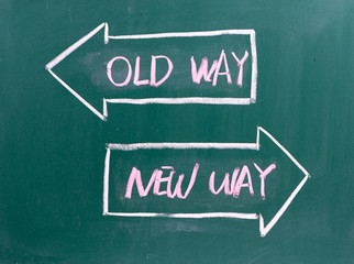 Old Way, New Way written on a blackboard with arrows pointing in the direction of the past and the future. A concept for adapting to change, improvement and development for the self or the business