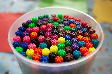 Selective focus shot of different color markers in a plastic jar