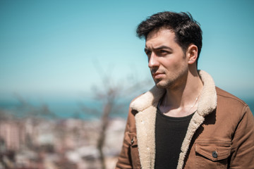 The young jacket man posing in outdoors.