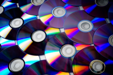 Background of CD and DVD discs laid out on a flat surface