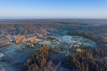Tilt shift effect small village aerial view among the autumn forest in an ecologically clean area.