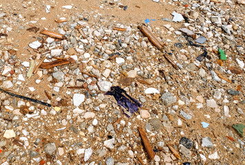 Remains of construction debris at a construction site with sand, gravel, fragments of tiles, plastic and metal