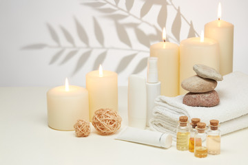 Spa still life with creams, essential oils, candles on light background. Healthy lifestyle, body...