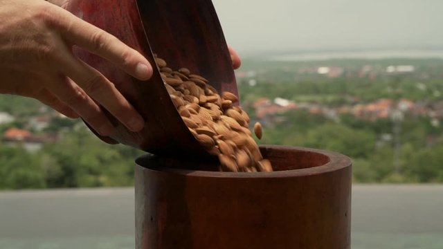 Getting almond oil, nuts are poured into a special machine for pressing