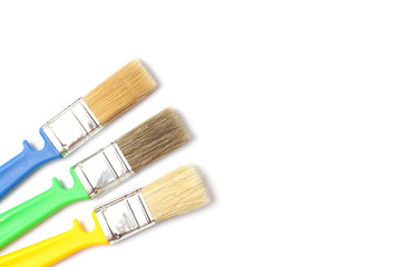 Colored paint brushes with plastic handles on a white background, place for text, isolate, flat...