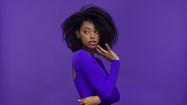african american woman smiling and posing isolated on purple 