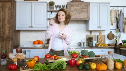 Pregnant Woman Eating Yogurt In The Kitchen. Healthy Food Concept.
