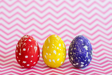 Multicolored Easter eggs on a geometric pink background.