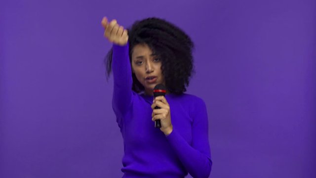 smiling african american woman singing isolated on purple 