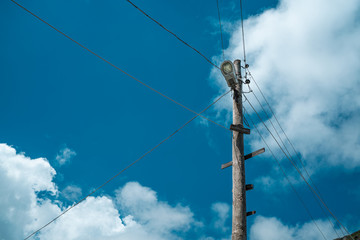 A wooden power pole with the sky in background