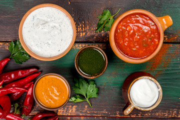Different types of sauces shot from above on a wooden background