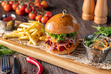 Vegetarian fresh burger with mushrooms and vegetables, served with french fries on a wooden board,...