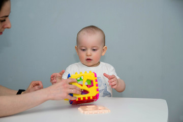 A small child plays at the white table in the sorter.