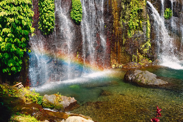 Fototapeta na wymiar Waterfall with crystal water and rainbow in tropical island