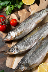 Smoked or dried smelt fish on a wooden Board on a brown wooden table. Top view with space for text	