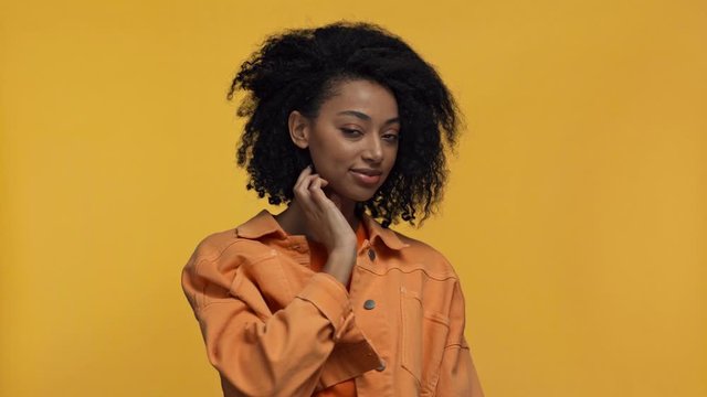 smiling african american woman holding ax isolated on yellow