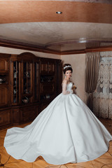 Morning of the bride. Beautiful bride in wedding dress with lace. Interior. Preparing the bride for the upcoming wedding. Wedding accessories. Fashion photo. Young attractive model.