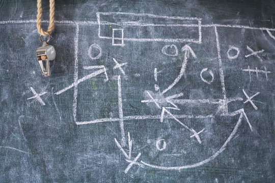 Soccer tactics diagram scribble and whistle of soccer or football referee on a black board, copy space