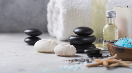 Fototapeta na wymiar Massage. Composition with candles, spa stones and salt on concrete background. Spa and wellness setting ready for beauty treatment.