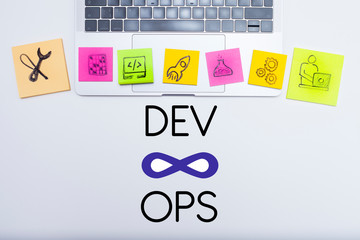 Devops concept. Developers and operations words and symbols, laptop on the white background. Space for your text.