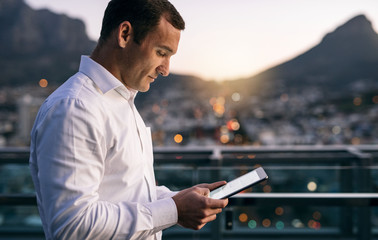 Focused businessman using a digital tablet on an office balcony