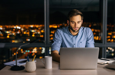 Young businessman working at his desk late at night
