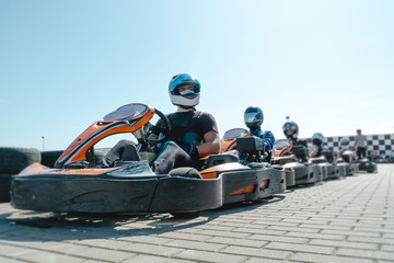 Equipped drivers are sitting in a racing car. Ready for battle, championship. Go karts racing, sreet karting, rent. extreme sport. fun entertainment for drivers